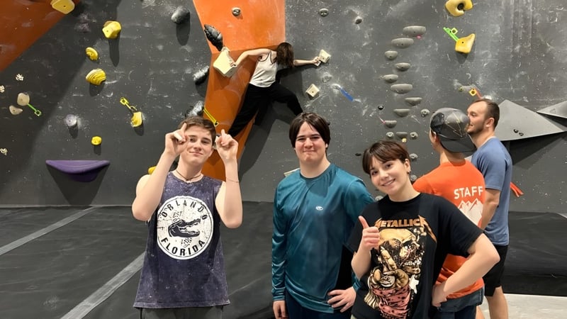 Schüler stehen vor der Kletterwand auf dem Campus der École secondaire publique Pierre de Blois.