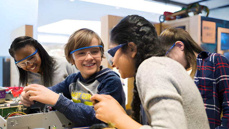 Schüler der Pitt Meadows Secondary School führen im Klassenzimmer mit Schutzbrillen eine praktische Aktivität durch.