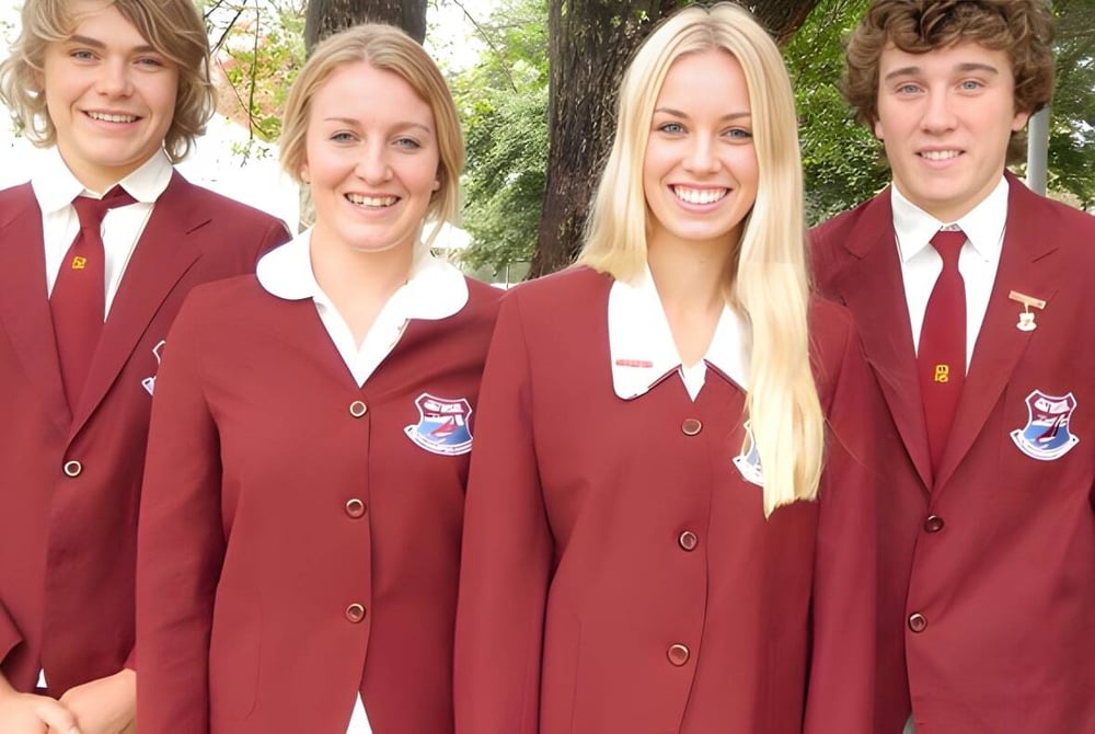 Vier Schülerinnen und Schüler der Pittwater High School posieren gemeinsam draußen vor Bäumen.