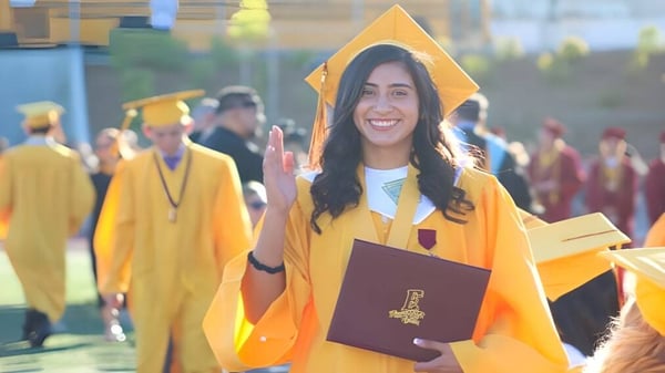 Eine Schülerin in gelbem Abschlussgewand hält ein Diplom während der Graduierungsfeier am Placentia-Yorba Linda Unified School District.
