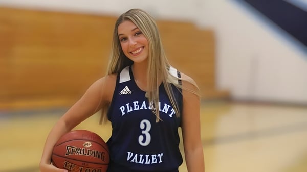 Eine Schülerin der Pleasant Valley High School steht mit einem Basketball in der Sporthalle.