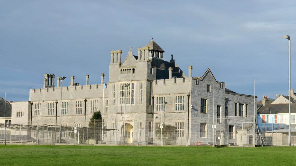 Ein mittelalterlich gestaltetes Schloss mit Türmen steht auf dem Gelände des Plymouth College vor einer Grasfläche.