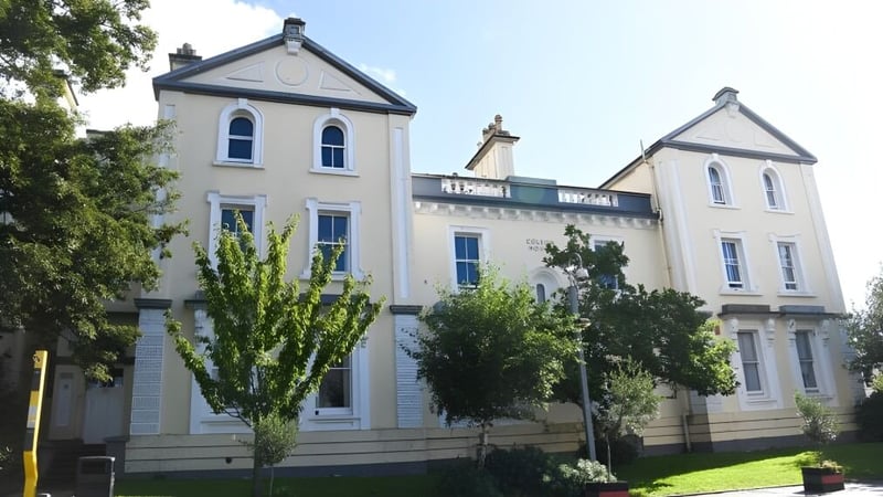 Das mehrstöckige weißes Gebäude mit aufwendiger Architektur auf dem Gelände des Plymouth College ist von Bäumen umgeben.