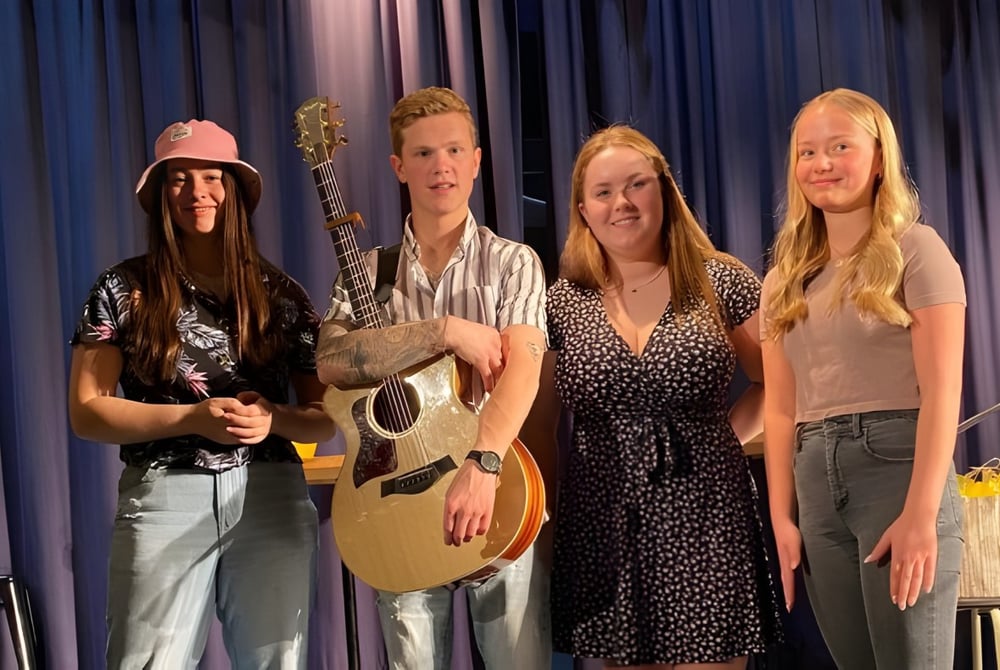 Vier Personen, darunter Schülerinnen und Schüler, stehen als Musiker auf der Bühne der Polyvalente Alexandre-J.-Savoie.