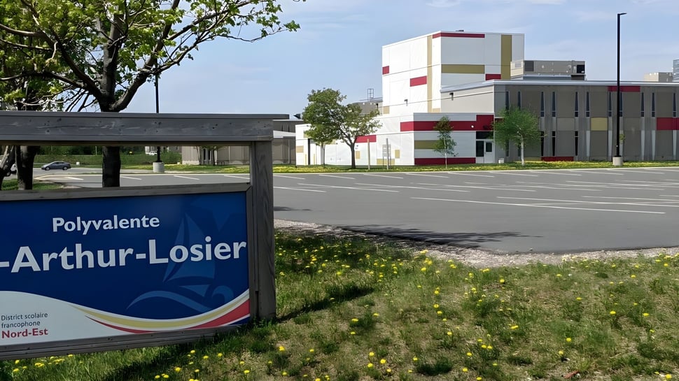 Das moderne mehrstöckige Gebäude der Polyvalente W.-A.-Losier ist von Bäumen und einer Rasenfläche umgeben.