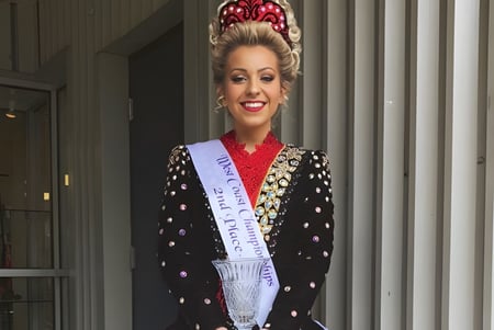 Eine Frau mit einer kunstvollen Krone steht vor einem Gebäude mit Säulen auf dem Campus der Port Moody Secondary School.