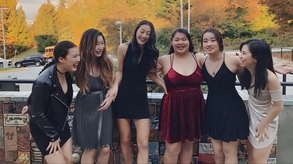 Eine Gruppe junger Schülerinnen der Port Moody Secondary School posiert vor herbstlichem Laub.