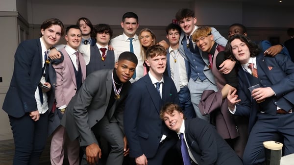 Eine Gruppe junger Männer in formeller Kleidung bei einer Feier auf dem Campus des Portlaoise College.