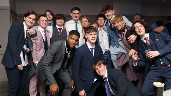 Eine Gruppe von Schülerinnen und Schülern in formeller Kleidung im Schulgebäude des Portlaoise College.