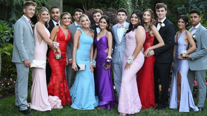 Schüler der Portmarnock Community School posieren in formeller Kleidung gemeinsam in einem Garten.