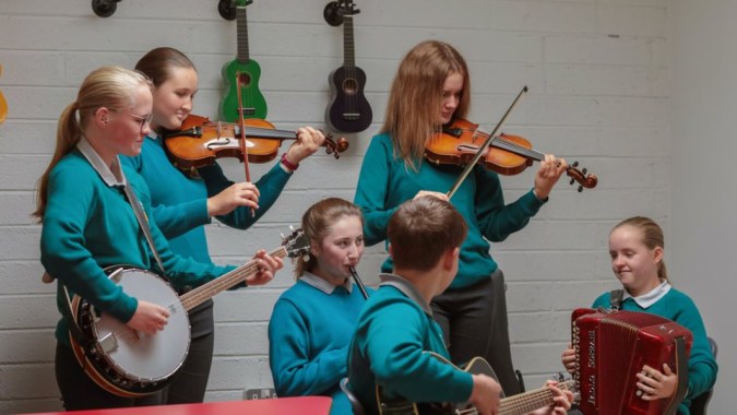 Eine Gruppe junger Musiker spielt in einem Musikraum auf dem Campus des Portumna Community College verschiedene Instrumente.