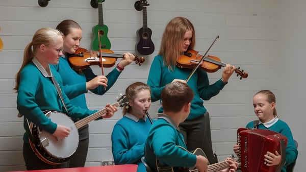 Eine Gruppe von Schülern spielt verschiedene Musikinstrumente im Musikraum des Portumna Community College.