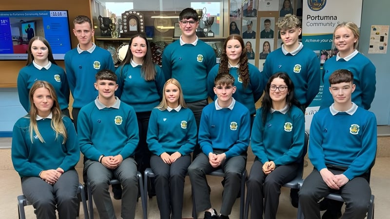 Eine Gruppe von Schülerinnen und Schülern in einheitlichen Uniformen im Schulgebäude des Portumna Community College.