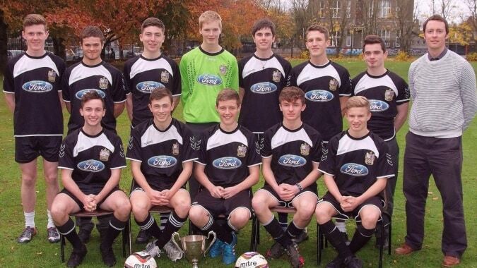 Eine Gruppe junger Fußballspielerinnen und -spieler posiert auf dem Gelände des Presentation Brothers College.