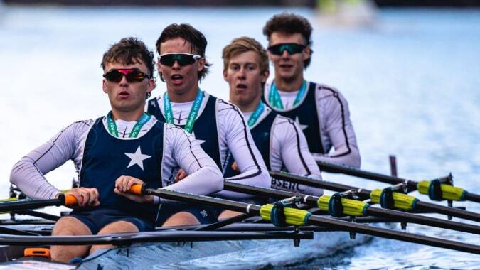 Eine Gruppe von Ruderern sitzt in Booten auf dem Wasser beim Training des Presentation Brothers College.