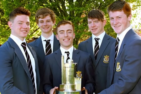 Schüler des Presentation College Galway posieren im Freien gemeinsam mit einer Trophäe.