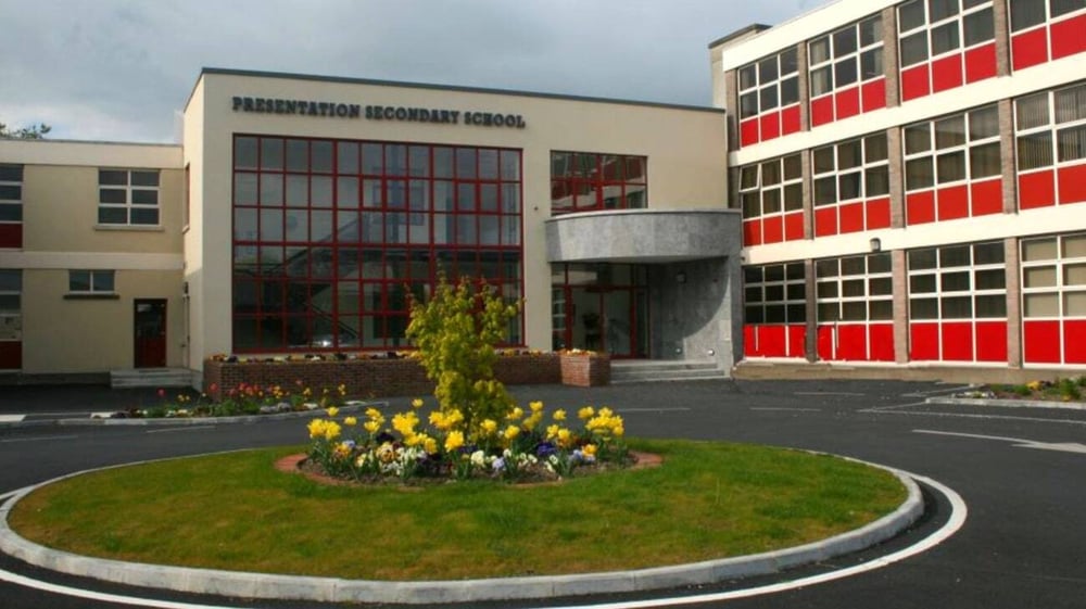 Das moderne Gebäude der Presentation Secondary School in Thurles mit großen Fenstern und rundem Gartenbeet im Vordergrund.
