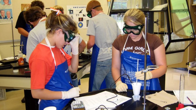Eine Gruppe Schülerinnen und Schüler versammelt sich in einem Raum der Presentation Secondary School in Thurles mit verschiedenen Ausstellungsstücken im Hintergrund.
