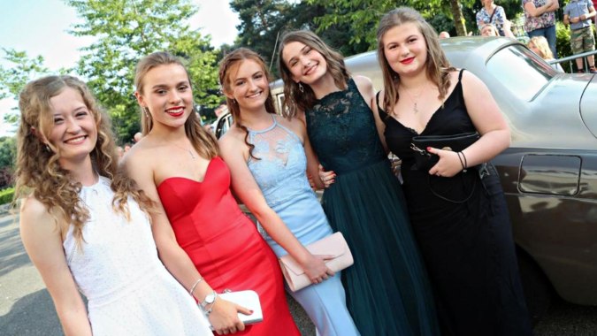 Eine Gruppe von fünf Schülerinnen der Presentation Secondary School in Tipperary steht vor einem Fahrzeug im grünen Außenbereich.