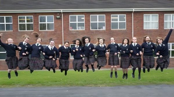Eine Gruppe von Schülerinnen und Schülern der Presentation Secondary School Kilkenny steht vor einem Backsteingebäude.