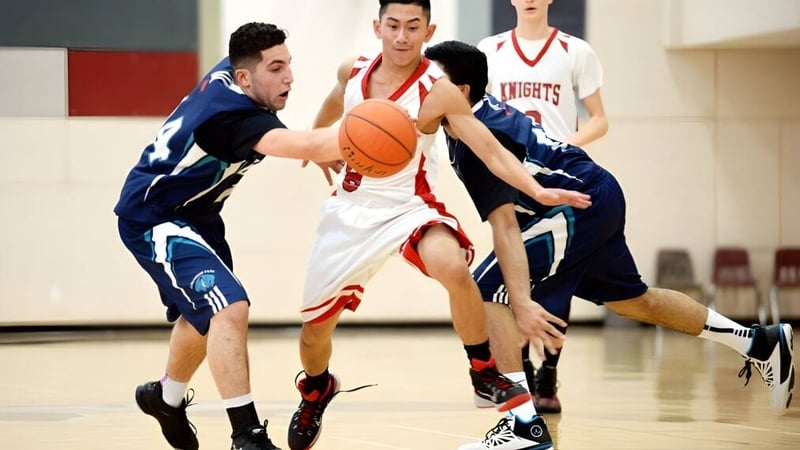 Zwei Schüler spielen Basketball im Wettkampf auf dem Sportplatz der Prince George Secondary School.