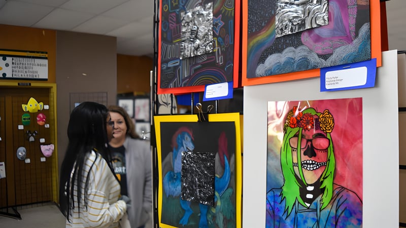 Ein Flur mit bunten Kunstwerken an den Wänden auf dem Campus der Prince George Secondary School mit einer Person im Vordergrund.