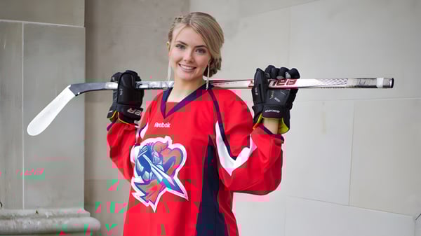 Eine Schülerin des Prince of Wales Collegiate steht mit einem Hockeyschlaeger vor einer Betonswand.