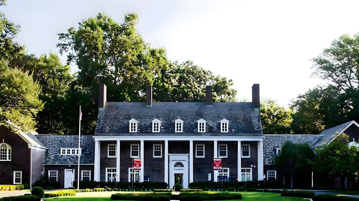 Ein kolonialstilartiges Herrenhaus steht auf dem Gelände der Princeton International School of Mathematics & Science umgeben von Bäumen und gepflegtem Rasen.