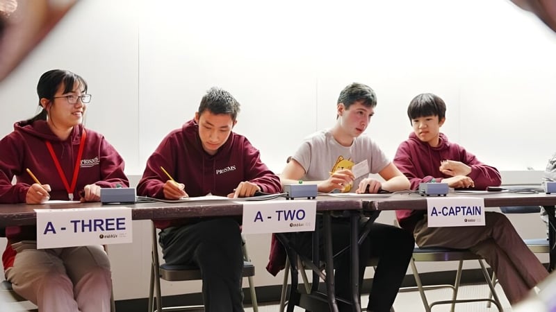 Vier Schülerinnen und Schüler arbeiten an Schreibtischen im Klassenraum der Princeton International School of Mathematics & Science.