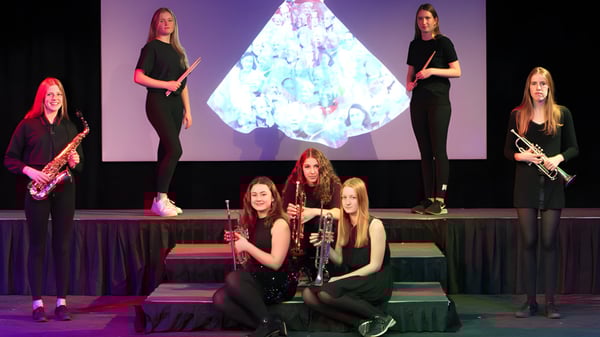 Eine Gruppe junger Schülerinnen führt auf der Bühne der Prior’s Field School vor einer bunten Kristallprojektion auf.