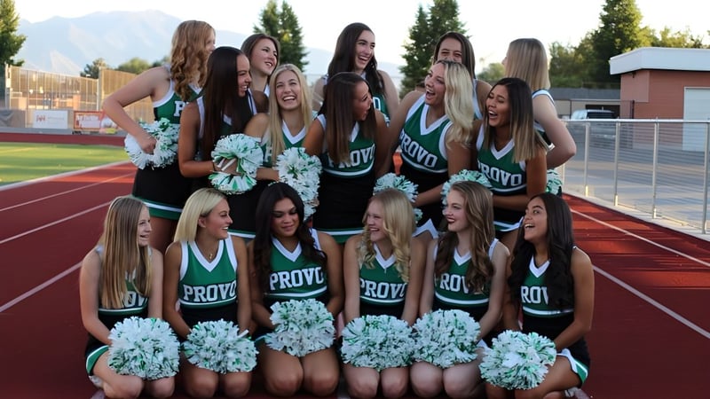 Eine Gruppe Cheerleader in einheitlicher Kleidung steht auf einem Sportfeld auf dem Campus der Provo City School District.