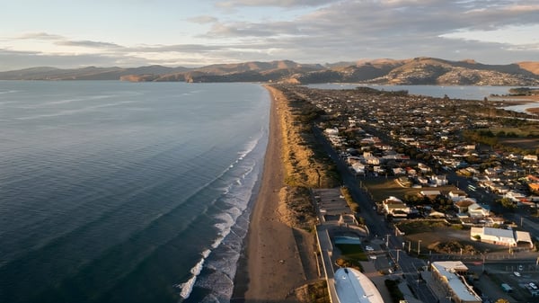 Blick auf die Küstenlandschaft mit Strand und Bergen nahe der Pukehohe High School.