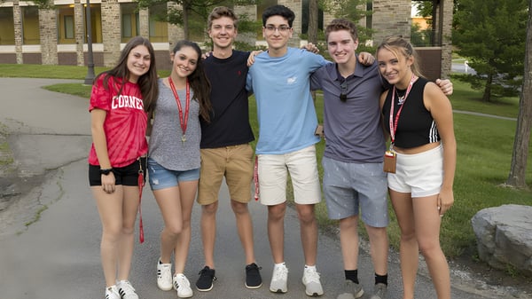 Eine Gruppe von Schülerinnen und Schülern steht zusammen in einem parkähnlichen Bereich auf dem Gelände der Quad Cities Christian School.