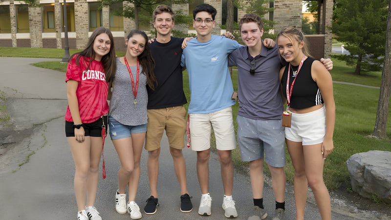 Eine Gruppe von Schülerinnen und Schülern steht zusammen in einem parkähnlichen Bereich auf dem Gelände der Quad Cities Christian School.
