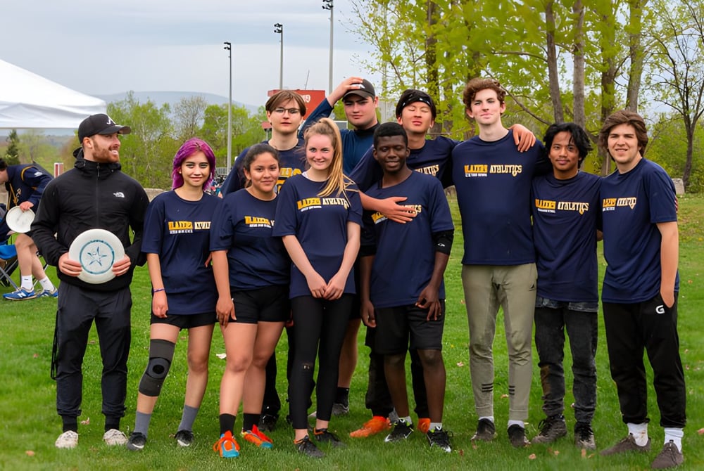 Eine Gruppe von Schülerinnen und Schülern der Québec High School steht als Sportteam gemeinsam auf einer Wiese.