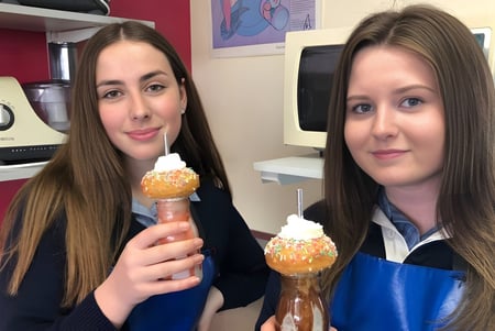 Zwei Schülerinnen der Queechy High School halten Eis in einer Küche mit bunter Dekoration.