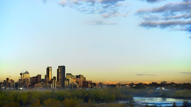 Blick auf die Stadt mit Wolkenkratzern vor farbigem Himmel nahe der Queen Elizabeth School.