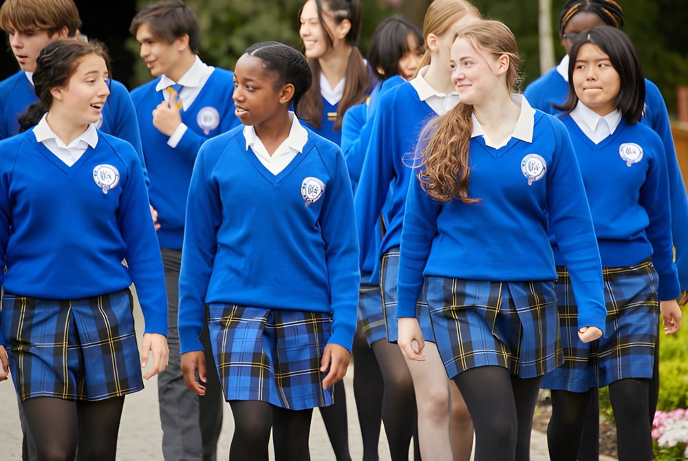 Schüler der Queen Ethelburga’s Collegiate stehen im Gartenbereich der Schule zusammen.