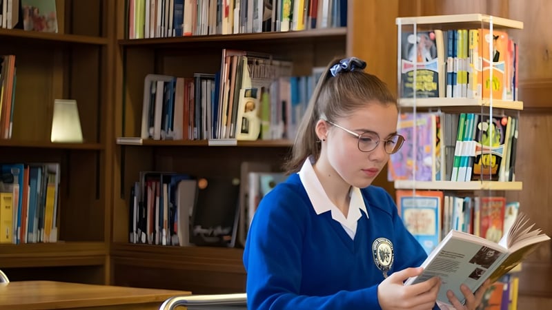 Eine Schülerin der Queen Ethelburga’s Collegiate liest konzentriert ein Buch in der Bibliothek.