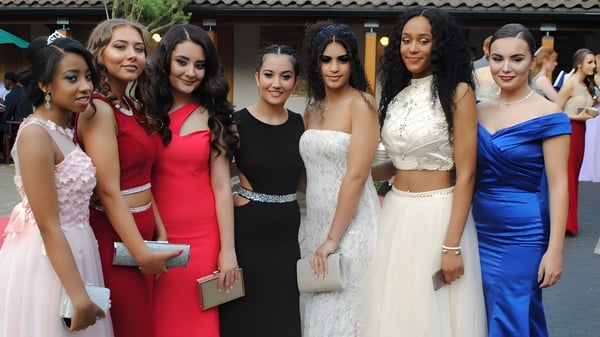 Eine Gruppe junger Frauen in formeller Kleidung steht vor einem Gebäude mit Ziegeldach auf dem Gelände der Queen Mary's School.