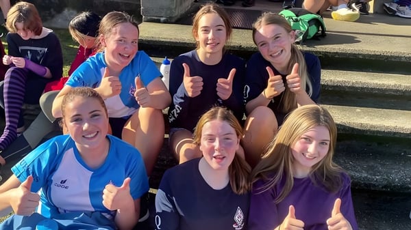 Eine Gruppe Schülerinnen der Queens High School zeigt im Freien Daumen hoch und ist fröhlich versammelt.