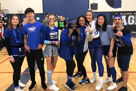 Eine Gruppe von Schülerinnen der R.E. Mountain Secondary School posiert in der Sporthalle der Schule.