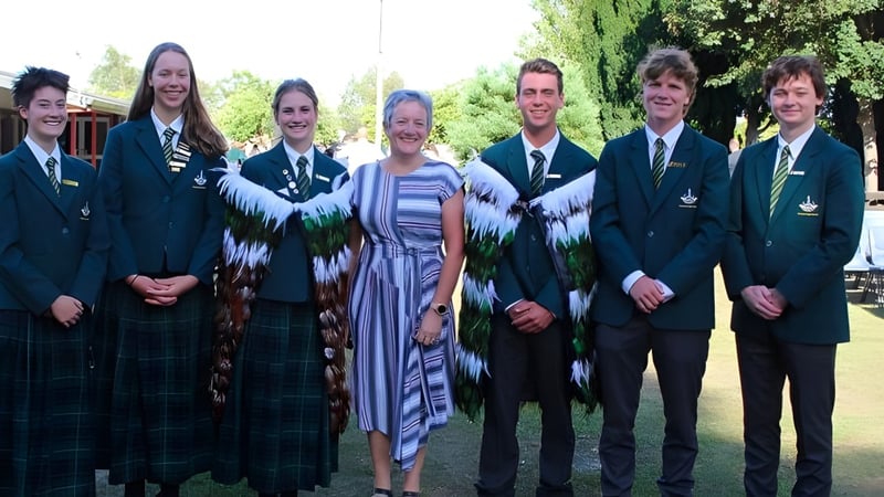 Eine Gruppe Schüler der Rangiora High School steht gemeinsam im Freien vor Bäumen und Grünflächen.