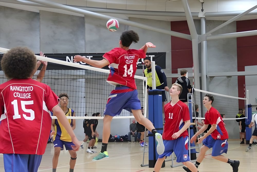 Schülerinnen und Schüler des Rangitoto College spielen ein Volleyballspiel in der Halle.
