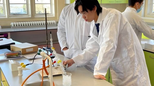 Eine Person in einem weißen Laborkittel arbeitet mit wissenschaftlichem Gerät im Labor des Ratcliffe College.