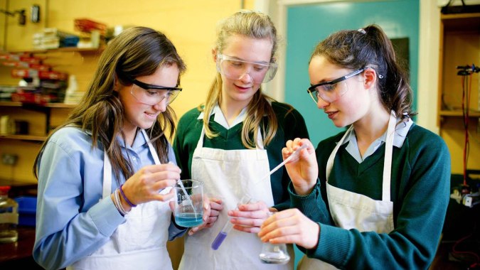 Drei Schülerinnen der Rathdown School führen gemeinsam ein Wissenschaftsexperiment in einem Klassenzimmer durch.