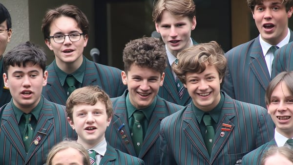 Eine Gruppe Schüler in grünen Uniformen ist auf dem Gelände des Rathkeale College zu sehen und zeigt expressive Gesichtsausdrücke.