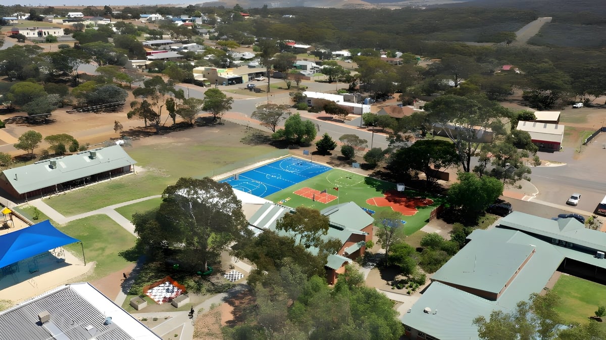 Der Sportplatz und Pool liegen vor Wohn- und Geschäftshäusern in der Hügellandschaft nahe der Ravensthorpe District High School.