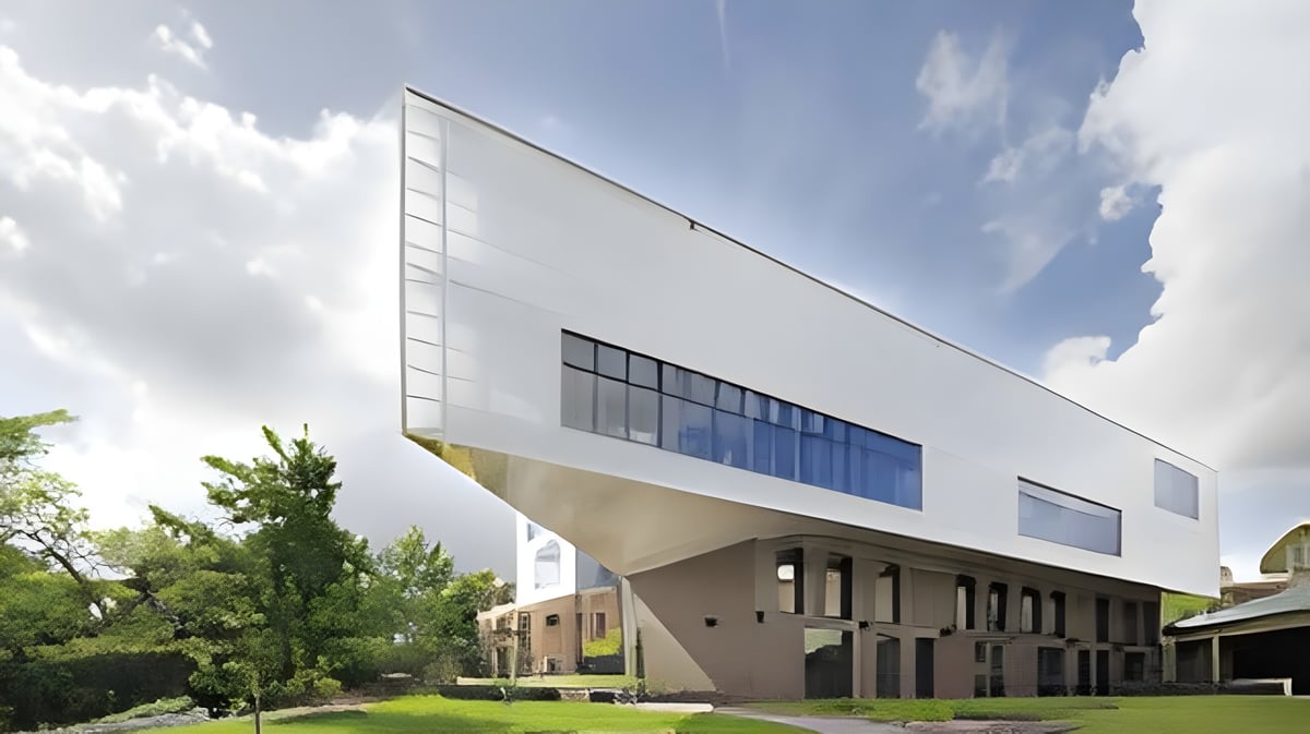 Das moderne weiße Gebäude der Ravenswood School for Girls ist von grünen Bäumen vor blauem Himmel umgeben.