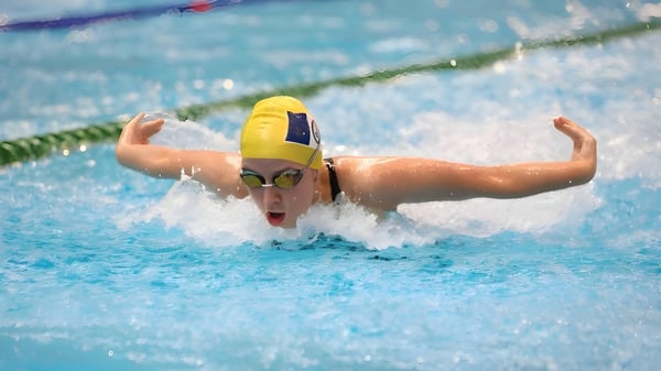 Eine Schwimmerin in gelbem Badeanzug zieht kraftvoll ihre Bahnen im Pool der Ravenswood School for Girls.